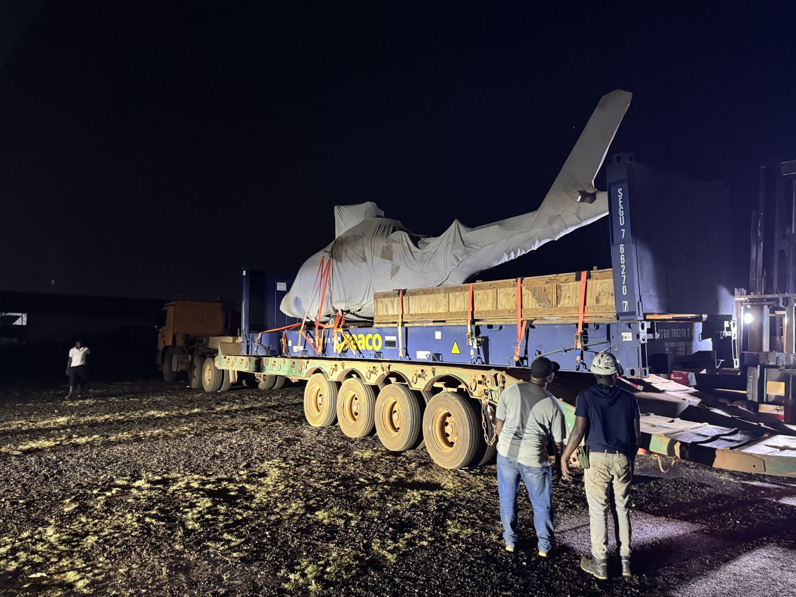 Fuselage d'aéronef sur porte-char multi-essieux, de nuit