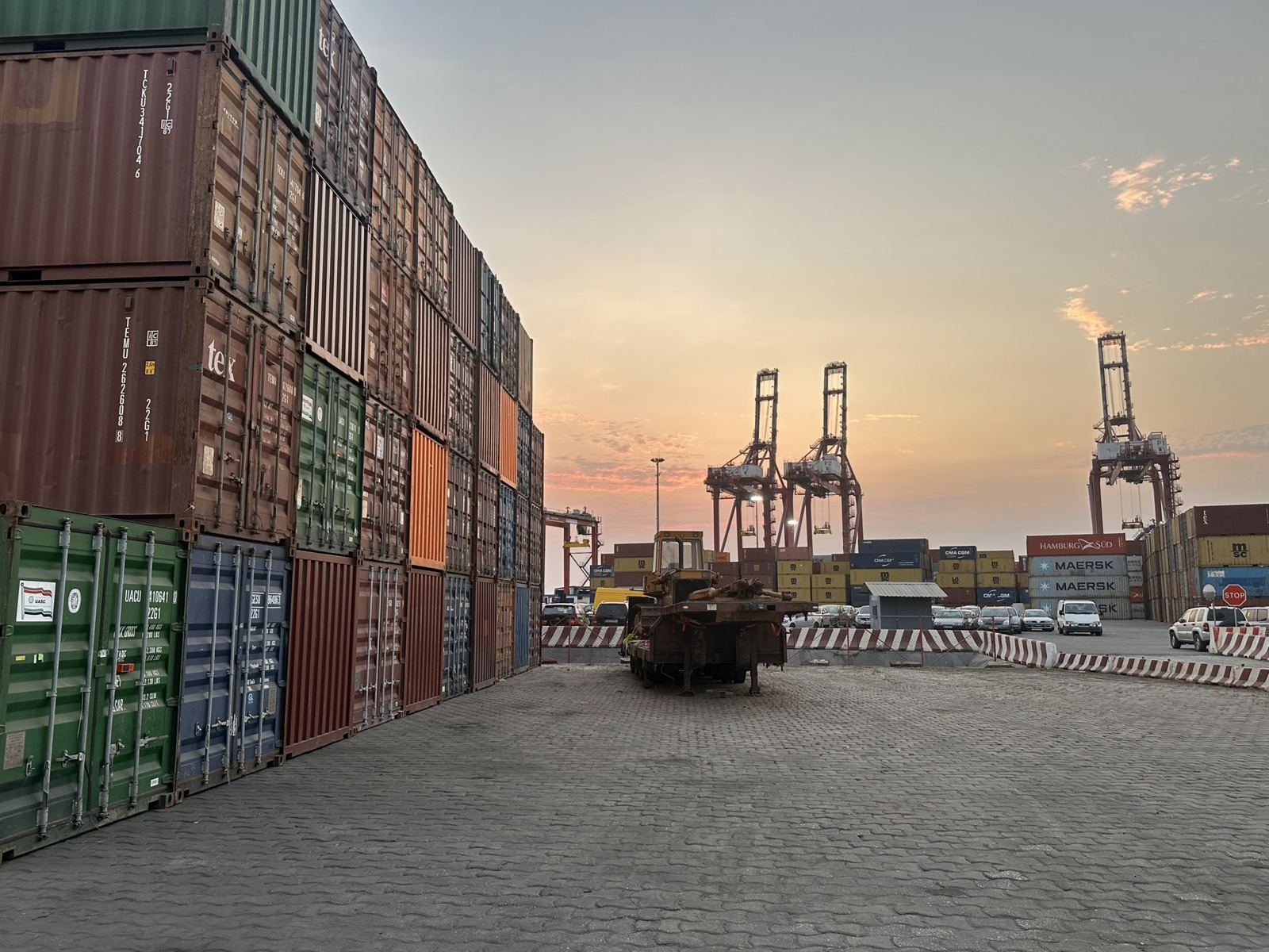 Piles de conteneurs et portiques au terminal, au coucher du soleil